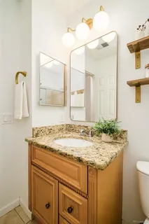 a bathroom with a granite countertop sink and a mirror