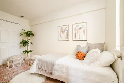 a bedroom with a bed and a potted plant