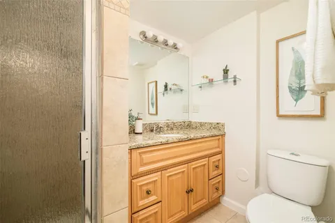 a bathroom with a granite countertop toilet sink and mirror