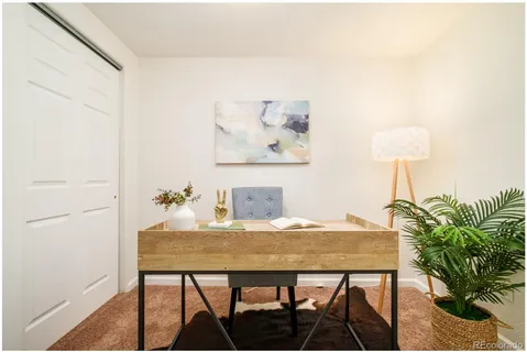 a view of a workspace room with furniture and a potted plant
