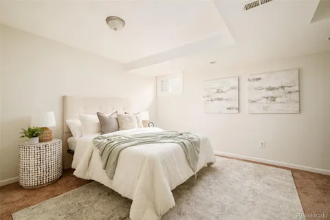 a bed room with a bed and painting on the wall