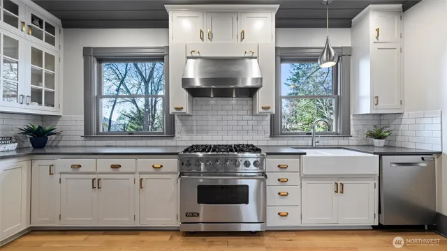 a large kitchen with stainless steel appliances granite countertop a stove a sink dishwasher and a stove with wooden floor