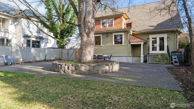 a view of a house with backyard and a tree
