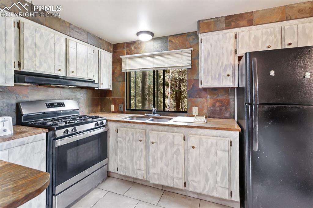 410 Rangeview Road Divide, CO 80814 - Photo 6 of 23 a kitchen with granite countertop a sink stove and refrigerator