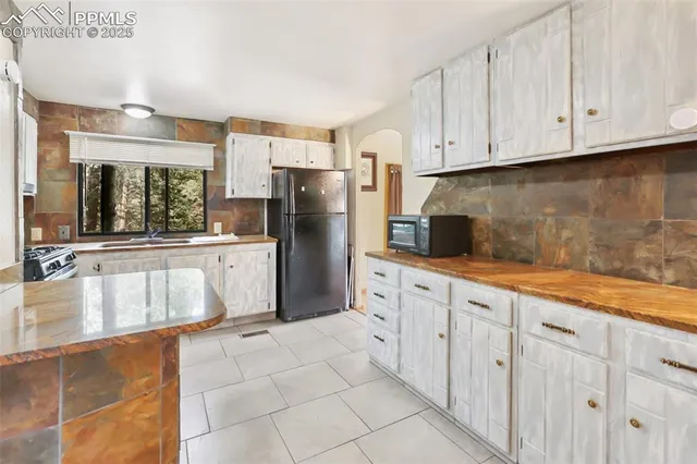 a kitchen with stainless steel appliances granite countertop a refrigerator and a sink