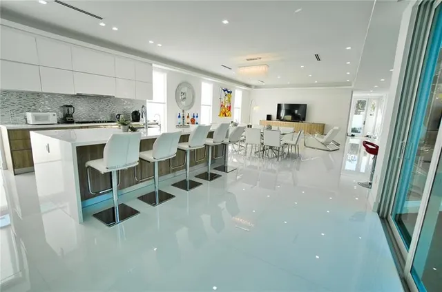 a large white kitchen with lots of counter space and furniture