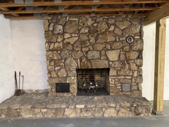 a view of empty room with a fireplace and a window