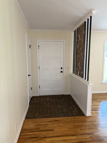 a view of a hallway with wooden floor and staircase