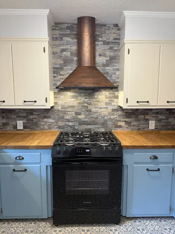 a stove top oven sitting inside of a kitchen