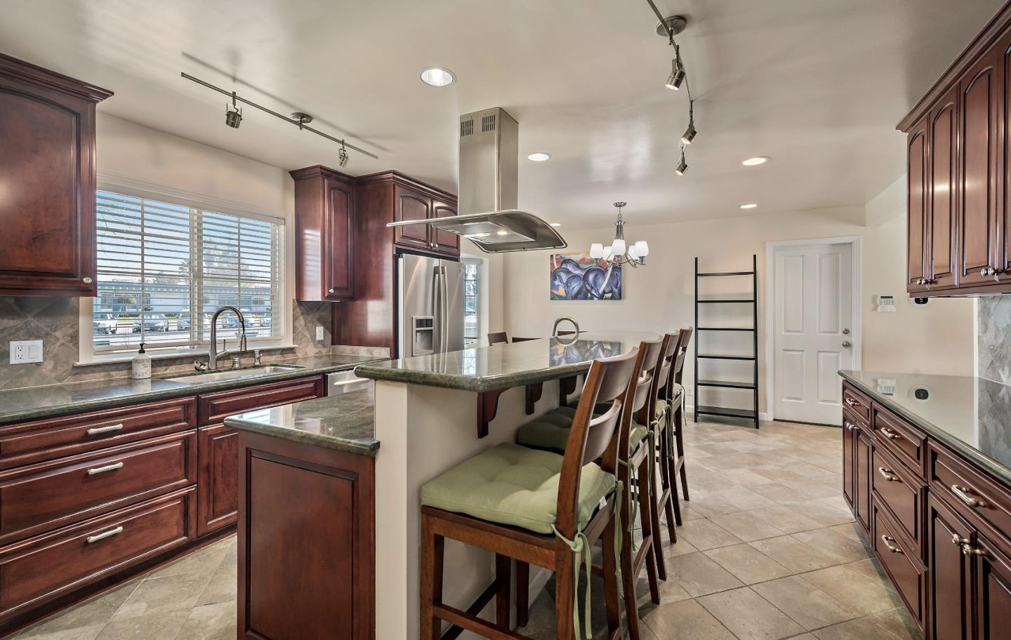 1019 Mango Avenue Sunnyvale, CA 94087 - Photo 6 of 17 a kitchen with stainless steel appliances kitchen island granite countertop a table chairs and a sink