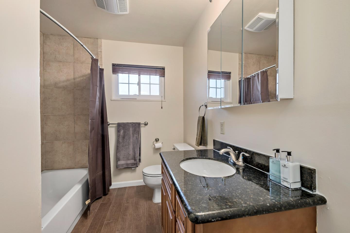 1019 Mango Avenue Sunnyvale, CA 94087 - Photo 9 of 17 a bathroom with a granite countertop sink a mirror and shower