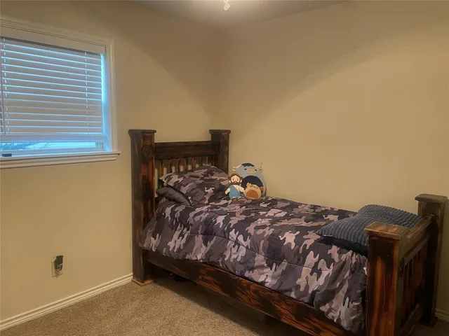 a bed sitting in a bedroom next to a window