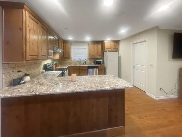 a large kitchen with kitchen island granite countertop a sink and cabinets