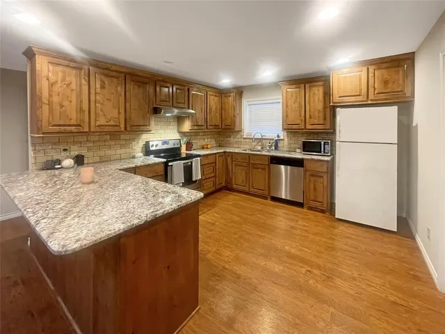a kitchen with stainless steel appliances granite countertop a sink stove and refrigerator