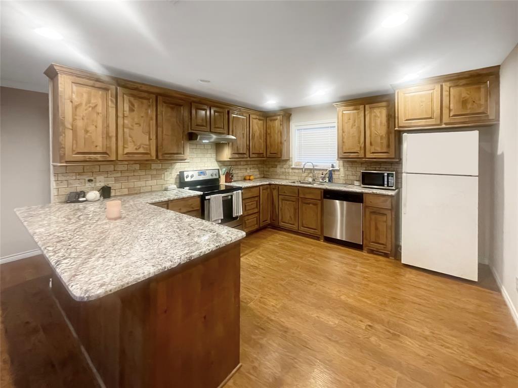 584 Highway 16 Graham, TX 76450 - Photo 7 of 22 a kitchen with stainless steel appliances granite countertop a sink stove refrigerator and cabinets