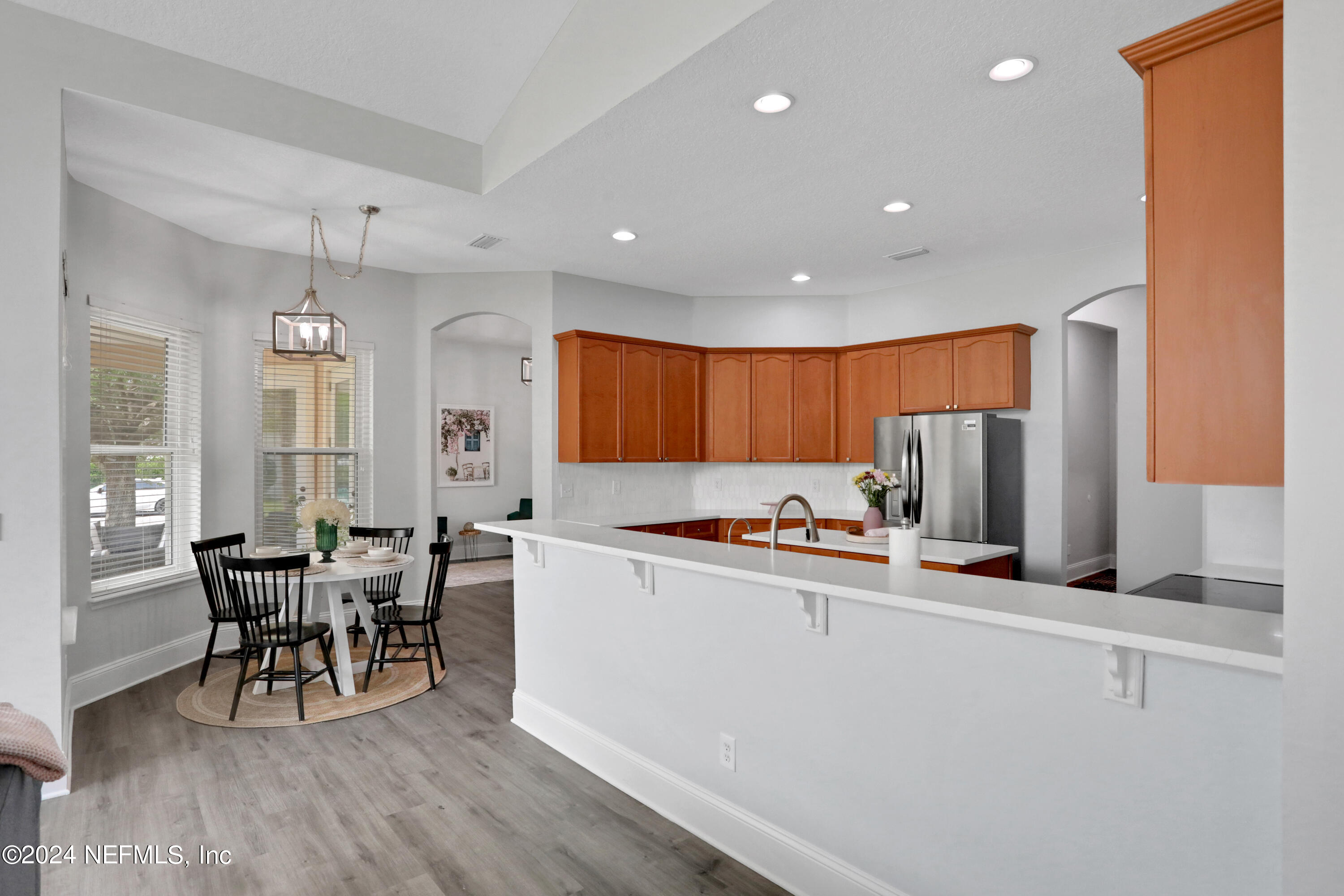 346 Porta Rosa Circle St. Augustine, FL 32092 - Photo 23 of 53 a kitchen with stainless steel appliances a dining table chairs and wooden floor
