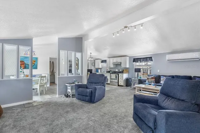 a living room with furniture and a view of kitchen
