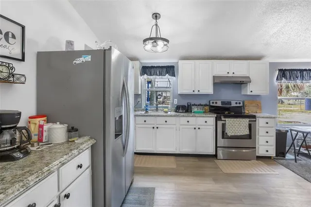a kitchen with stainless steel appliances granite countertop a refrigerator and stove