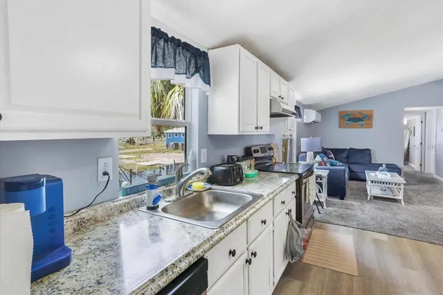 a kitchen with stainless steel appliances granite countertop a sink a stove and wooden cabinets