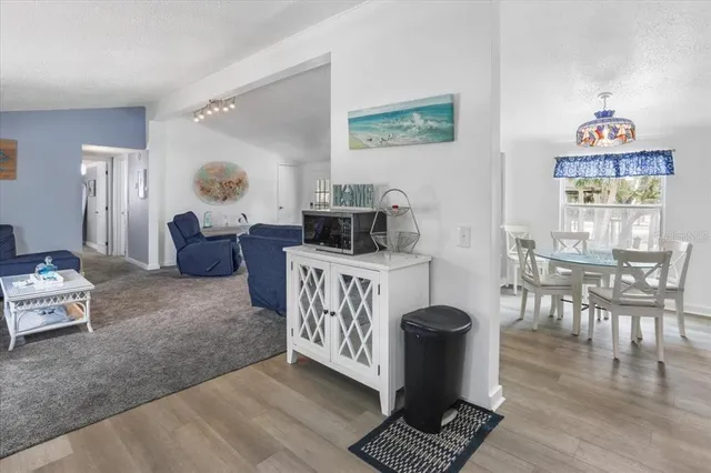 a living room with furniture a dining table and a stove with wooden floor