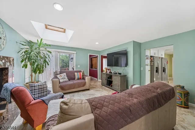 a living room with furniture a chandelier and a flat screen tv