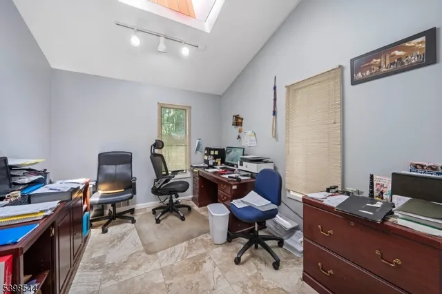a view of a workspace with furniture and a window