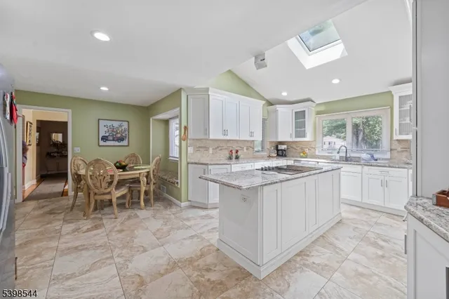 a kitchen with granite countertop sink window and white stainless steel appliances