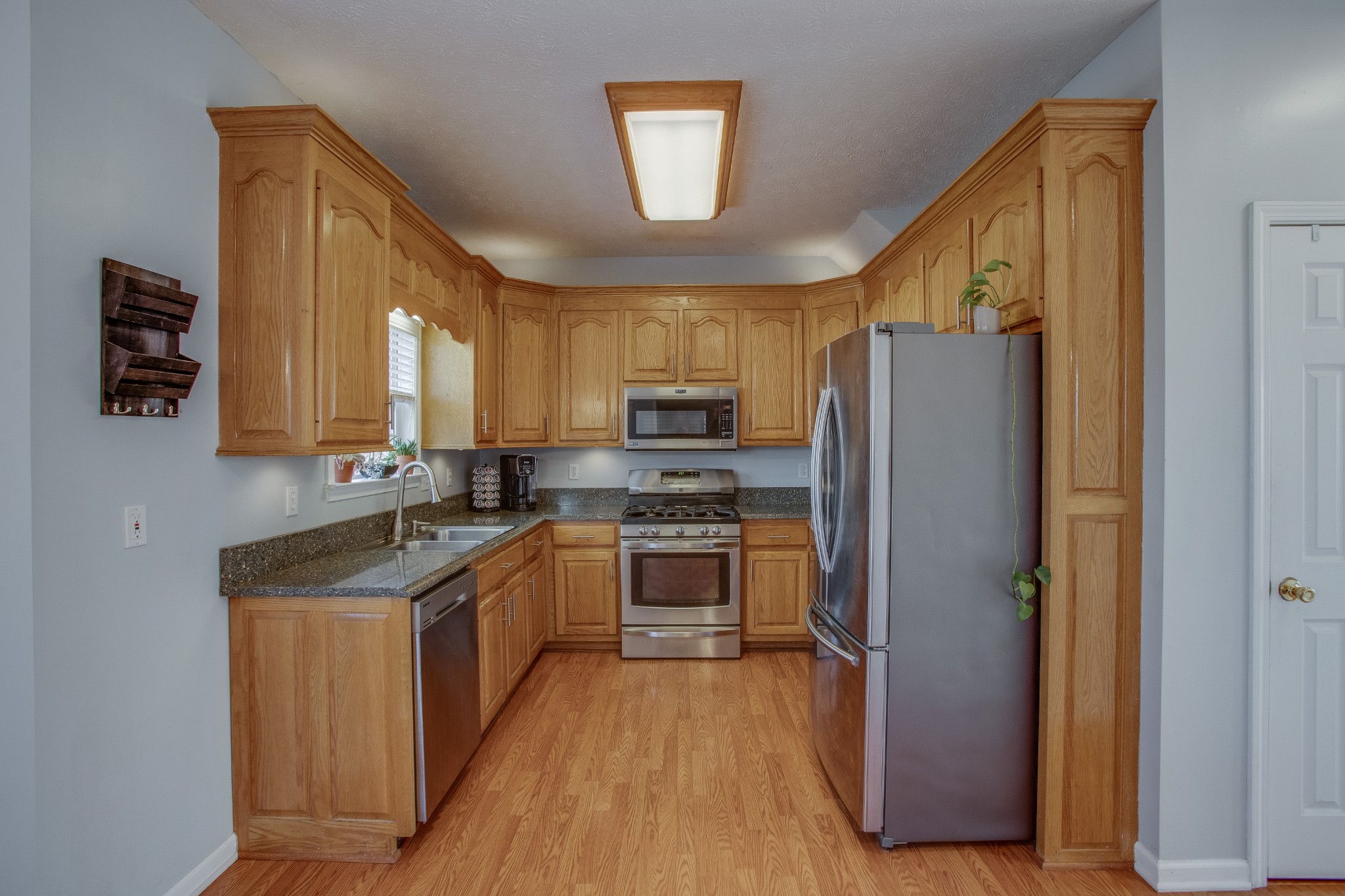 2918 Buckner Lane Spring Hill, TN 37174 - Photo 15 of 54 a kitchen with stainless steel appliances granite countertop a refrigerator a sink dishwasher a stove with wooden floor and cabinets