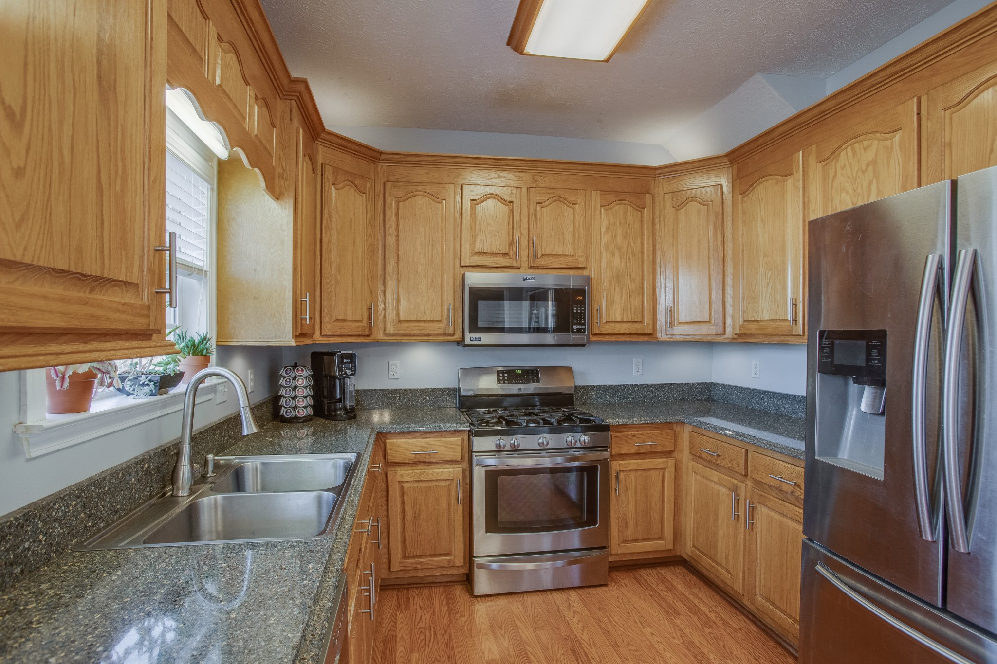 2918 Buckner Lane Spring Hill, TN 37174 - Photo 17 of 54 a kitchen with stainless steel appliances granite countertop a stove a sink and a refrigerator