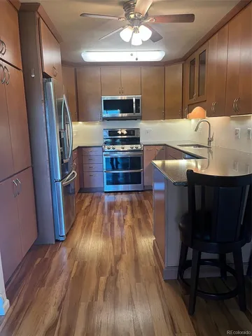 a kitchen with granite countertop a stove refrigerator and microwave