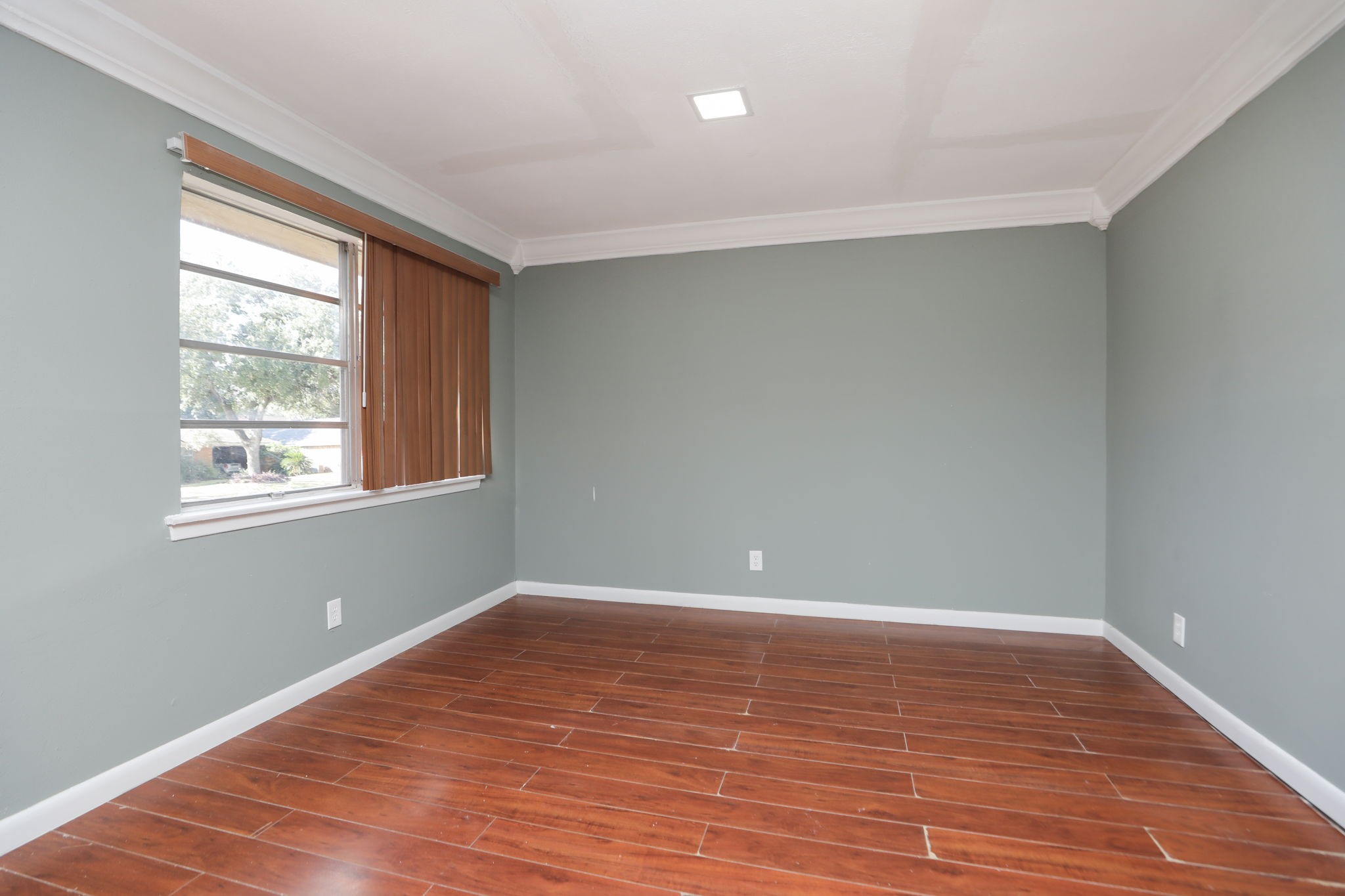 8235 Dover Street Houston, TX 77061 - Photo 9 of 36 wooden floor in an empty room with a window