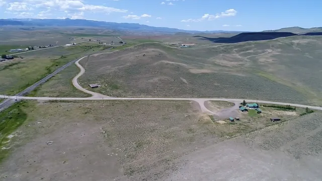 a view of a lush green hillside next to a yard