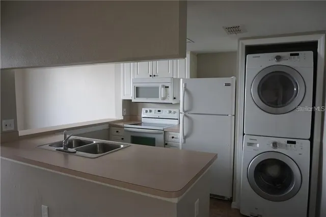 a kitchen with a refrigerator sink stove and cabinets