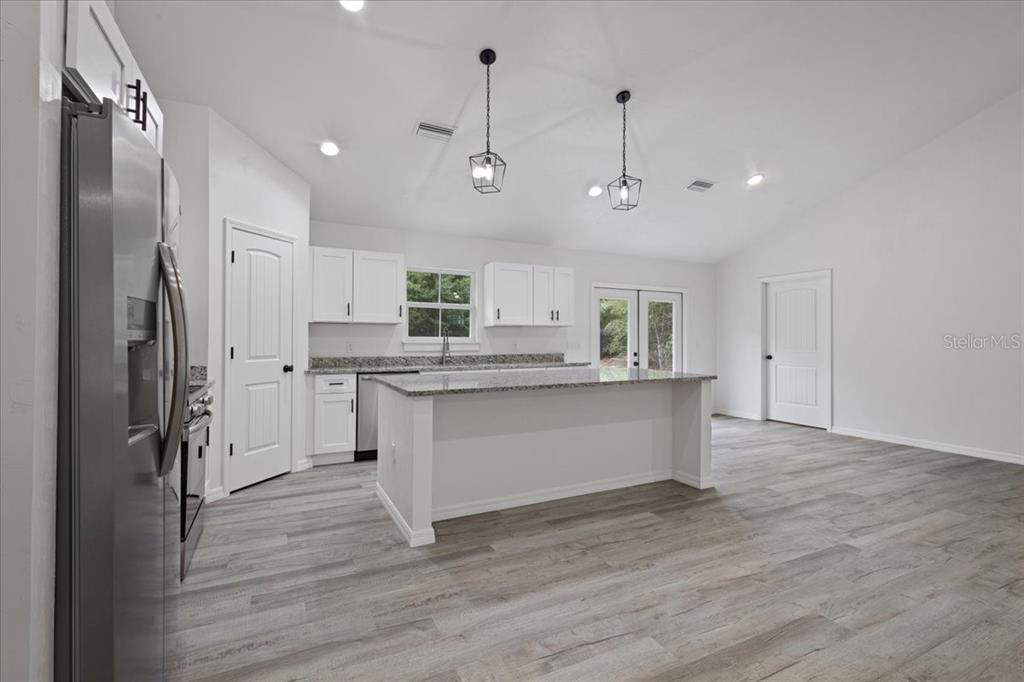 4899 Northwest 36th Street Bell, FL 32619 - Photo 14 of 67 a kitchen with white cabinets and stainless steel appliances