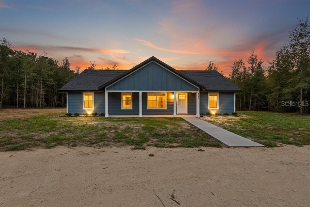 4899 Northwest 36th Street Bell, FL 32619 - Photo 2 of 67 a view of a yard in front of a house with plants and large tree