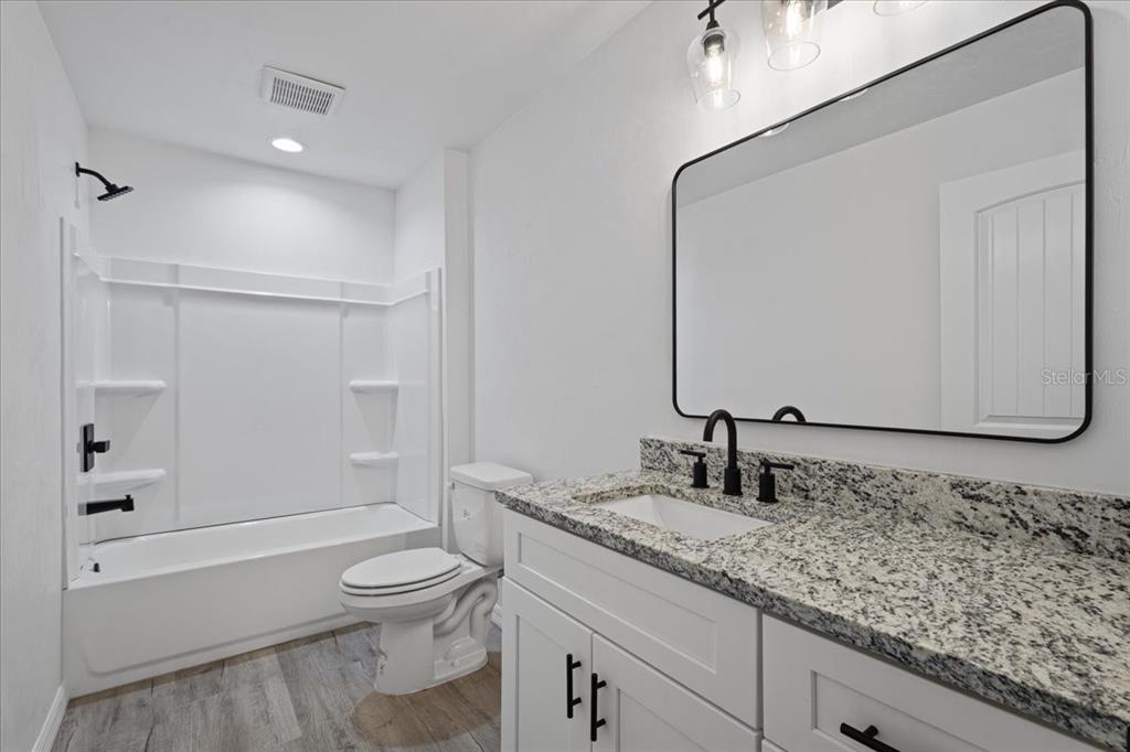 4899 Northwest 36th Street Bell, FL 32619 - Photo 24 of 67 a bathroom with a granite countertop sink toilet and shower