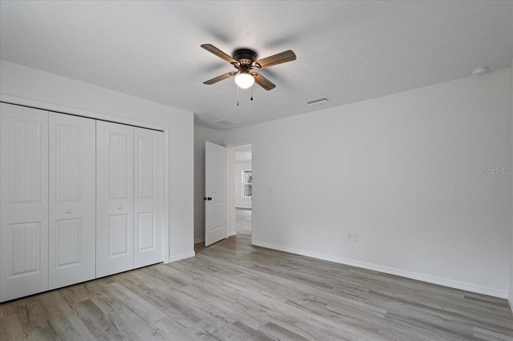 4899 Northwest 36th Street Bell, FL 32619 - Photo 26 of 67 a view of an empty room with wooden floor and a ceiling fan