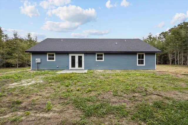 a view of a yard with plants and trees