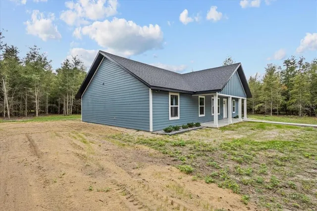 a view of house with backyard and trees
