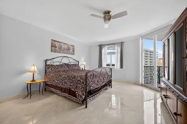 a bedroom with a bed chandelier and a window