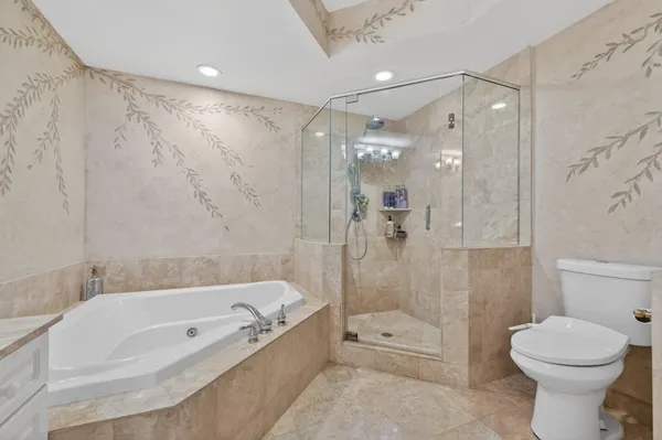 a bathroom with a tub a toilet and a shower