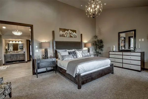 a spacious bedroom with a bed and a chandelier