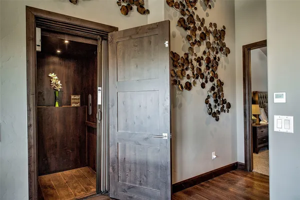 a view of a hallway with wooden floor and staircase