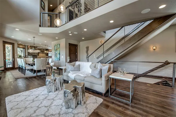 a living room with couches and kitchen view with wooden floor