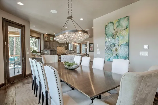 a view of a dining room with furniture a chandelier and wooden floor