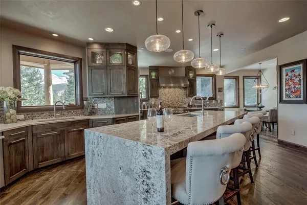 a large kitchen with granite countertop a sink a counter space appliances and a large window