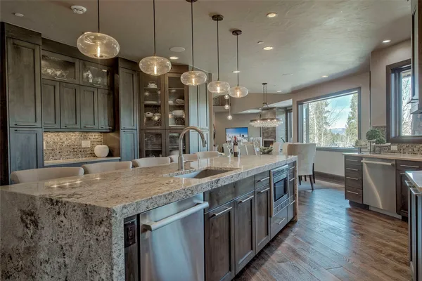 a kitchen with stainless steel appliances granite countertop counter space a sink cabinets and wooden floor