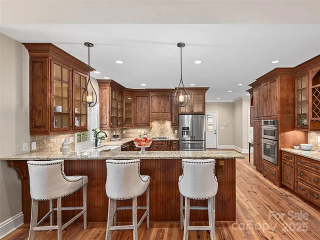 a kitchen with granite countertop a sink cabinets and stainless steel appliances
