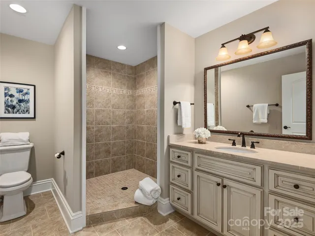 a bathroom with a toilet sink double vanity and mirror