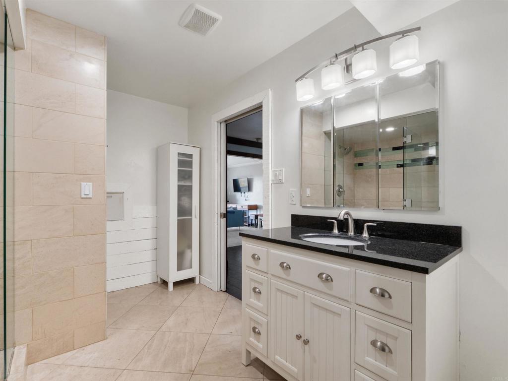 852 Dewitt Avenue Encinitas, CA 92024 - Photo 22 of 41 a bathroom with a granite countertop sink a mirror and a shower